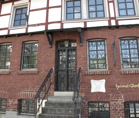 Half-timbered house with red brick façade, staircase and door. Sign with "heimat+zunftmuseum" in Adenau. Year of construction 1667 visible., © Uschi Regh