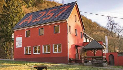 A red building with the inscription "A257" on the roof. It is located in a rural setting and has a covered seating area in the front.