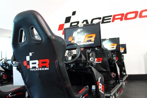 Ein modernes Rennsimulator-Setup mit mehreren Fahrersitzen. Die Sitze sind mit Monitoren und Lenkrädern ausgestattet.