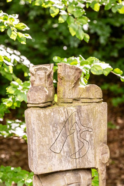 Holzklotz mit großem A udn großem S für AhrSteig darüber stehen zwei geschnitzte Wanderschuhe 