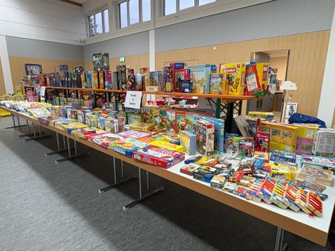 Ein farbenfrohes Plakat für einen Spielzeugbasar mit verschiedenen Spielzeugen und Kinderartikeln. Der Basar findet am 24. Oktober 2026 in der Elsberghalle statt.