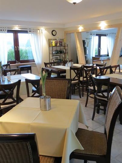 Un restaurant confortable avec des tables et des chaises. L'atmosphère est claire et accueillante.