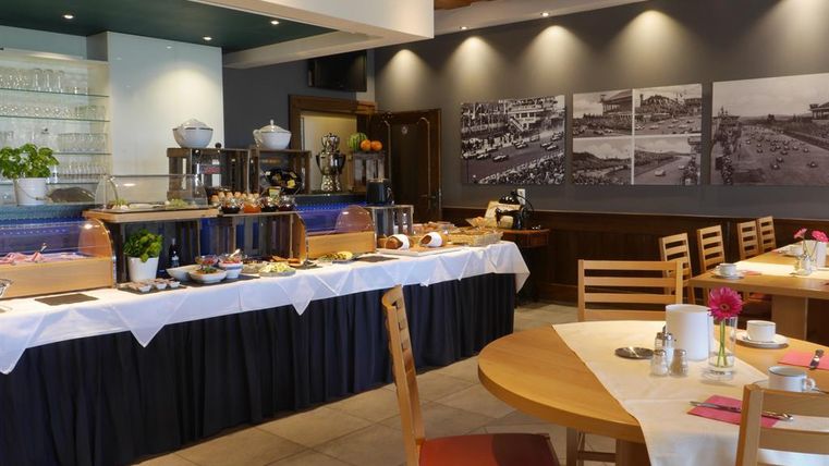 An elegant breakfast area with a buffet full of delights. Bright furniture and appealing wall art create an inviting atmosphere.