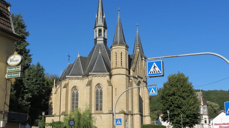 Eine schöne Kirche mit spitzen Türmen und detaillierter Architektur. Der klare blaue Himmel ergänzt die Szenerie.
