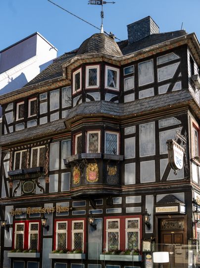 Fachwerkhaus Blaue Ecke in Adenau mit dekorativen Elementen und Schildern.