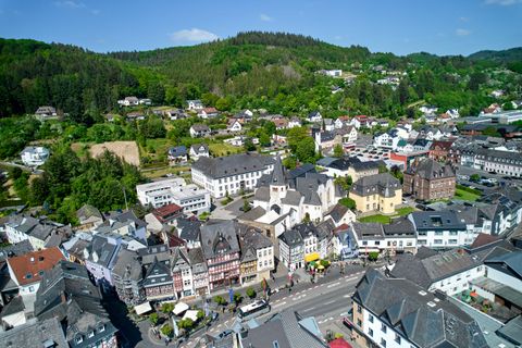 Hauptstraße mit Häusern in Adenau im Hintergrund Wald 