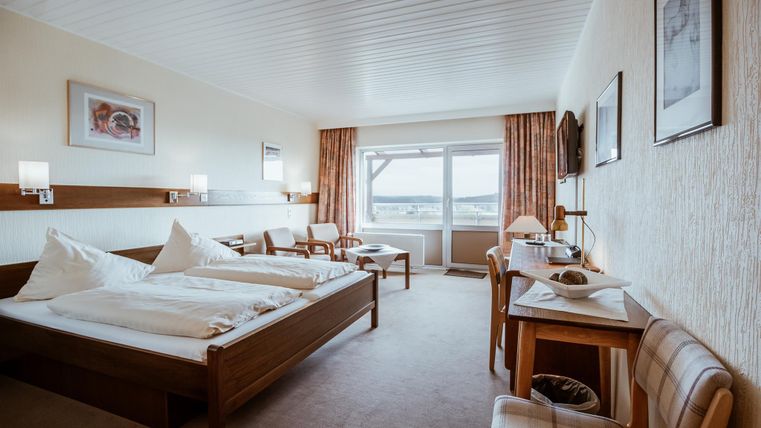 Een gezellig hotelkamer met twee eenpersoonsbedden en uitzicht op het landschap. De inrichting is licht en uitnodigend.