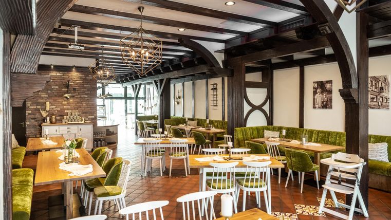 Een stijlvol restaurant met houten plafonds en gezellige zitplaatsen. De inrichting combineert moderne en rustieke elementen.