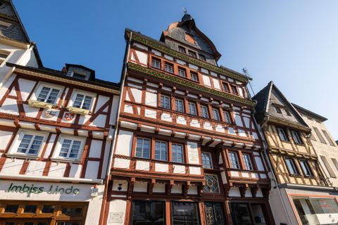 Ein historisches Fachwerkhaus mit einem auffälligen Dach und bunten Fenstern. Die Architektur zeigt den typischen Stil der Region.