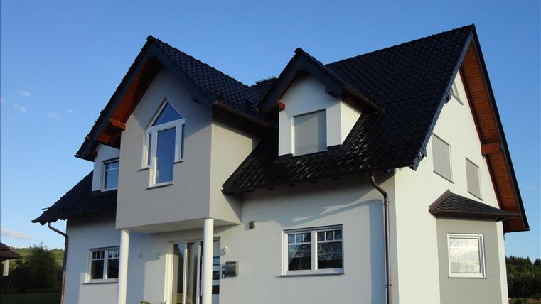 A modern house with a shed roof and white walls. The windows are large and provide plenty of daylight.
