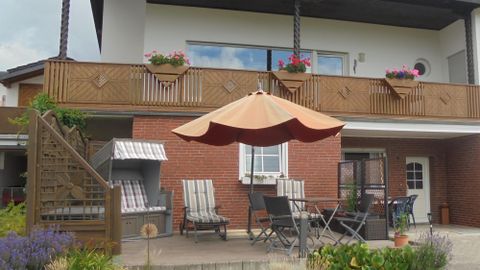 Entrance and terrace of the holiday apartment Nürburgblick with beach chair and garden furniture