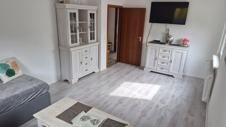 A bright living room with modern furniture in white. The room has a pleasant atmosphere and plenty of daylight.
