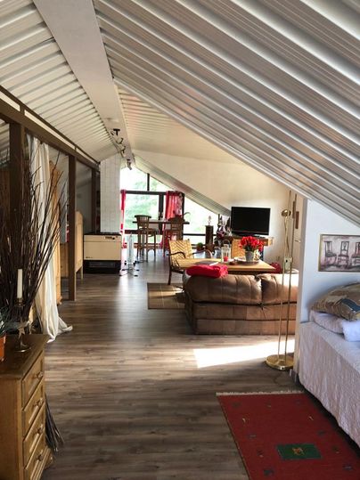 A bright and cozy living space with a sloped roof. The decor is modern and invites relaxation.