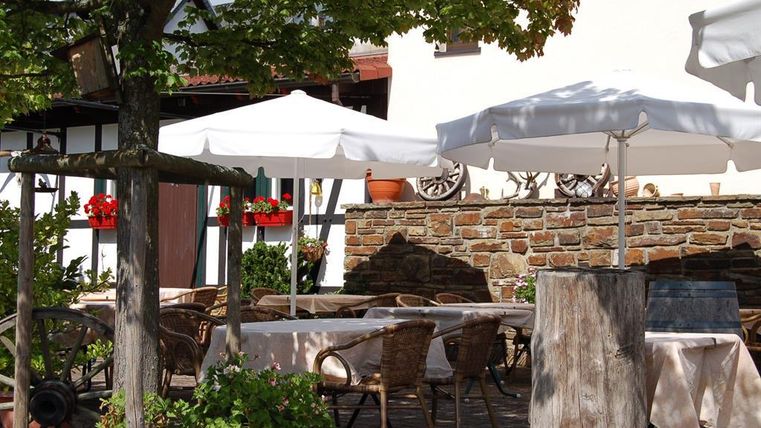 Een uitnodigend terras met parasols en gezellige stoelen. Omgeven door een groene landschap en decoratieve planten.