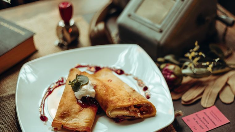 Gefüllte, goldbraun gebackene Pfannkuchen auf weißem Teller