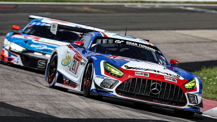 Ein Rennwagen fährt auf einer Rennstrecke. Im Hintergrund ist ein weiterer Wagen zu sehen.