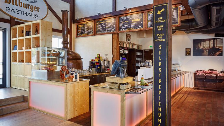 Une auberge accueillante avec un comptoir en bois et des éléments modernes. L'espace est lumineux et confortablement aménagé.