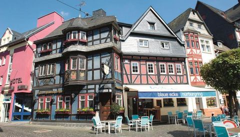 A historic building with a charming half-timbered style. The street is quiet and has cozy outdoor seating.