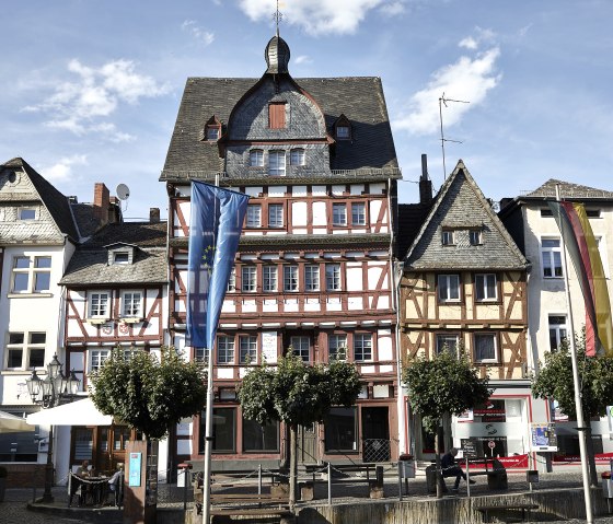 Vakwerkhuizen in het historische centrum van Adenau, versierd met de Europese vlag en de Duitse vlag. Mensen zitten buiten onder parasols., &copy; TI Hocheifel-N&uuml;rburgring,Jonathan_Andrews