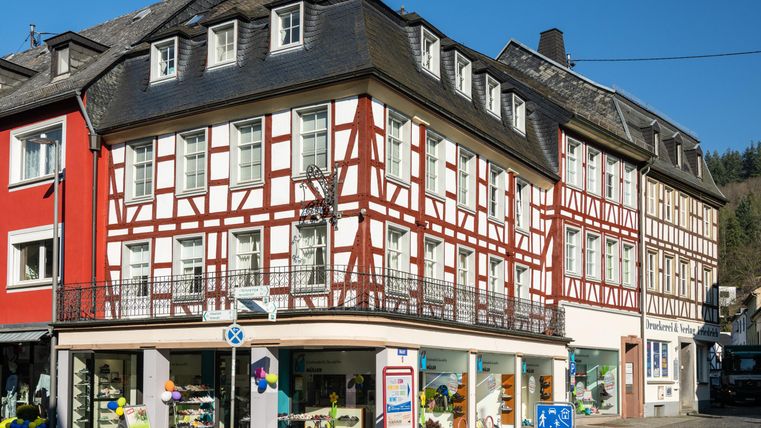Ein traditionelles Fachwerkhaus in einer malerischen Stadt. Die bunten Fassaden und der klare Himmel schaffen eine einladende Atmosphäre.