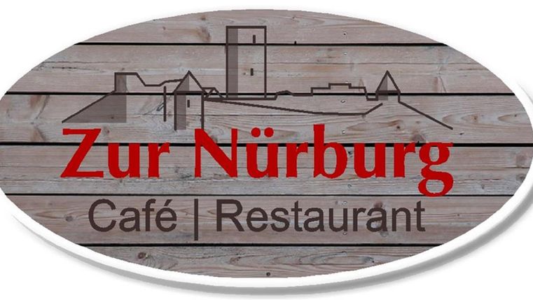 A sign of the café and restaurant "Zur Nürburg" made of wood. It features a simple and appealing design.