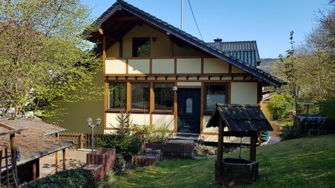 Une maison charmante avec un grand jardin. Le ciel est dégagé et l'environnement est verdoyant.