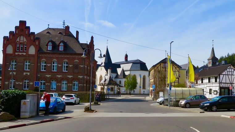 Une vue pittoresque de la ville avec des bâtiments historiques et une église en arrière-plan. Les rues sont calmes, et les couleurs des maisons créent une atmosphère accueillante.