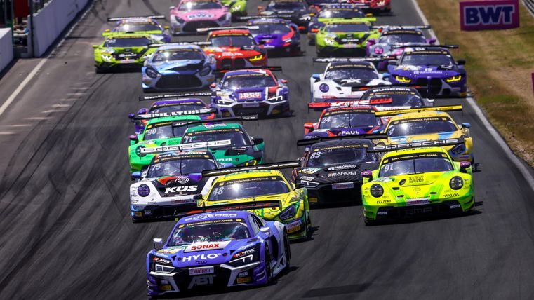 Ein spannendes Autorennen mit vielen bunten Rennwagen auf der Strecke. Die Fahrzeuge sind dicht beieinander und rasen Richtung Ziel.