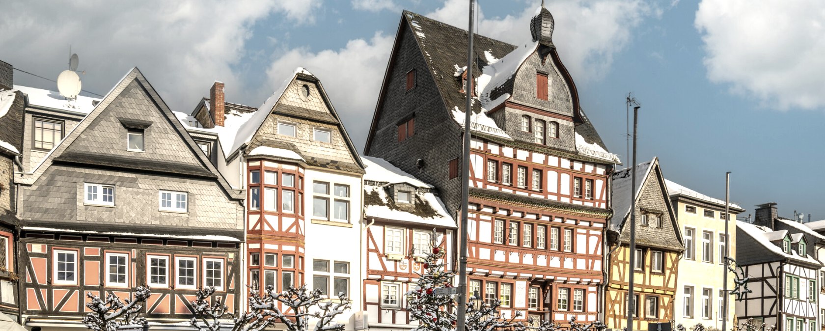 Verschneite Fachwerkh&auml;user in Adenau, bei sonnigem Winterwetter. Die bunten Fassaden und der blaue Himmel schaffen eine malerische Winterkulisse., &copy; Ahrtaltourismus,D.Ketz