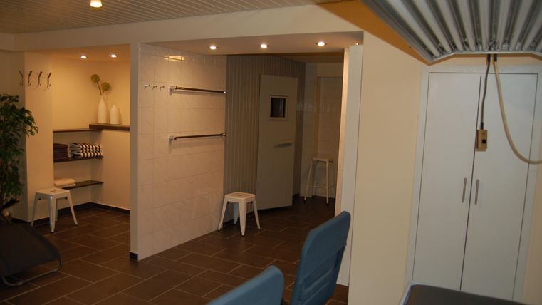 Een gezellige binnenruimte met moderne zitplaatsen en lichte muren. Er is een douche en planken, ideaal voor ontspanning en comfort.