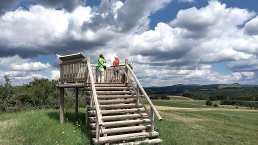 Zwei Personen stehen auf einer Holzplattform und blicken in die weite Landschaft. Der Himmel ist teils bew&ouml;lkt, teils blau., &copy; Siegfried M&uuml;ller