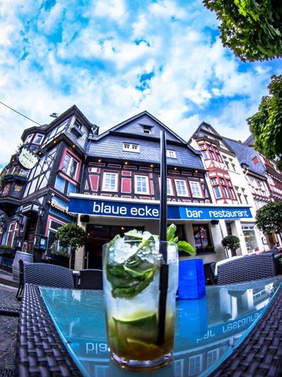 A restaurant called "Blaue Ecke" in a historic building. In the foreground is a refreshing cocktail on a glass table.